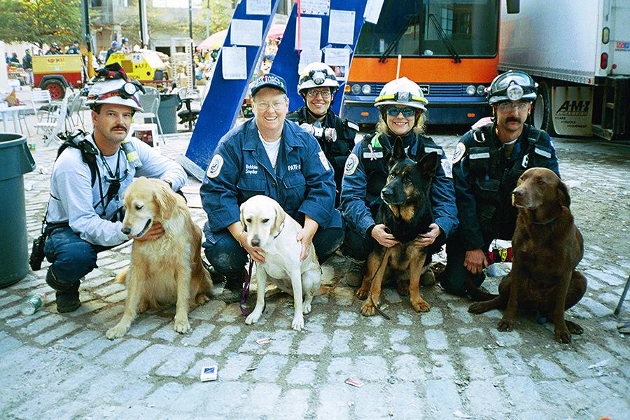 Cynthia Otto, who provided veterinary assistance to canine search teams at Ground Zero, poses with rescue and recovery workers and four canines.