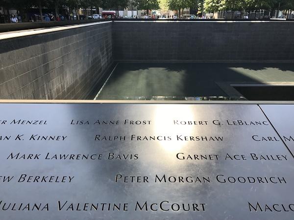 The names of Mark Lawrence Bavis and Garnet Ace Bailey are shown on a bronze parapet at the Memorial’s south pool. Sunlight is reflecting on their names and the names of other victims.
