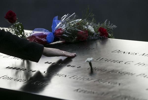 A person places his or her hand at a name on the 9/11 Memorial during the 16th anniversary commemoration ceremony at Memorial plaza.