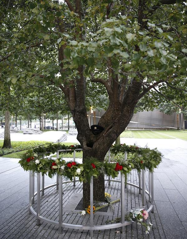 Flowers and other tributes have been left at the Survivor Tree on Memorial plaza. A first responder’s formal hat has been placed on the tree’s trunk.