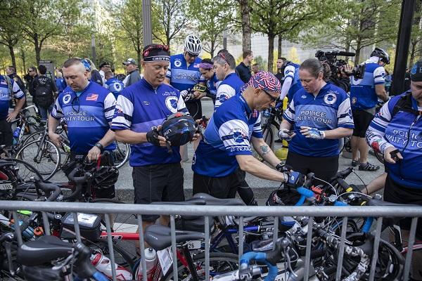 A group of cyclists stand near their bikes on the Memorial Plaza as they get ready to take part in a ride honoring police officers killed in the line of duty.
