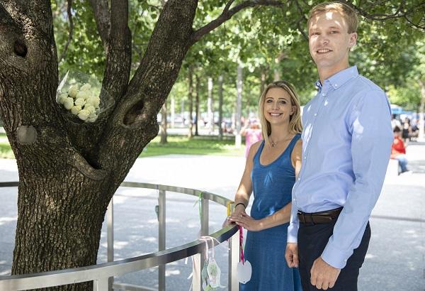 Sean Egan and Caitlin Leavey, whose FDNY fathers both died in the 9/11 attacks, pose for a photo beside the Survivor Tree at Memorial plaza.