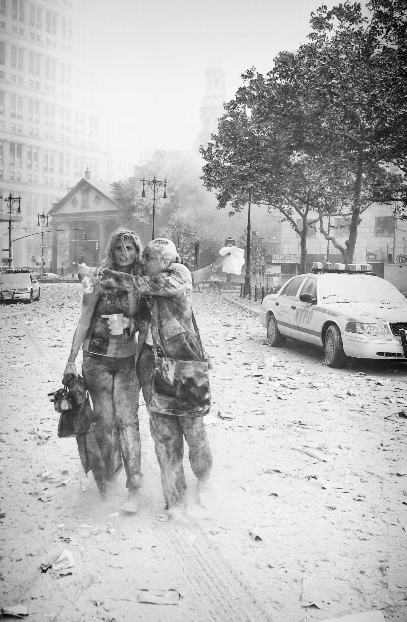 Joanne Capestro and a colleague are covered in dust as they flee the World Trade Center site on September 11. A cloud of dust covers the surrounding area, including the street and a police car.