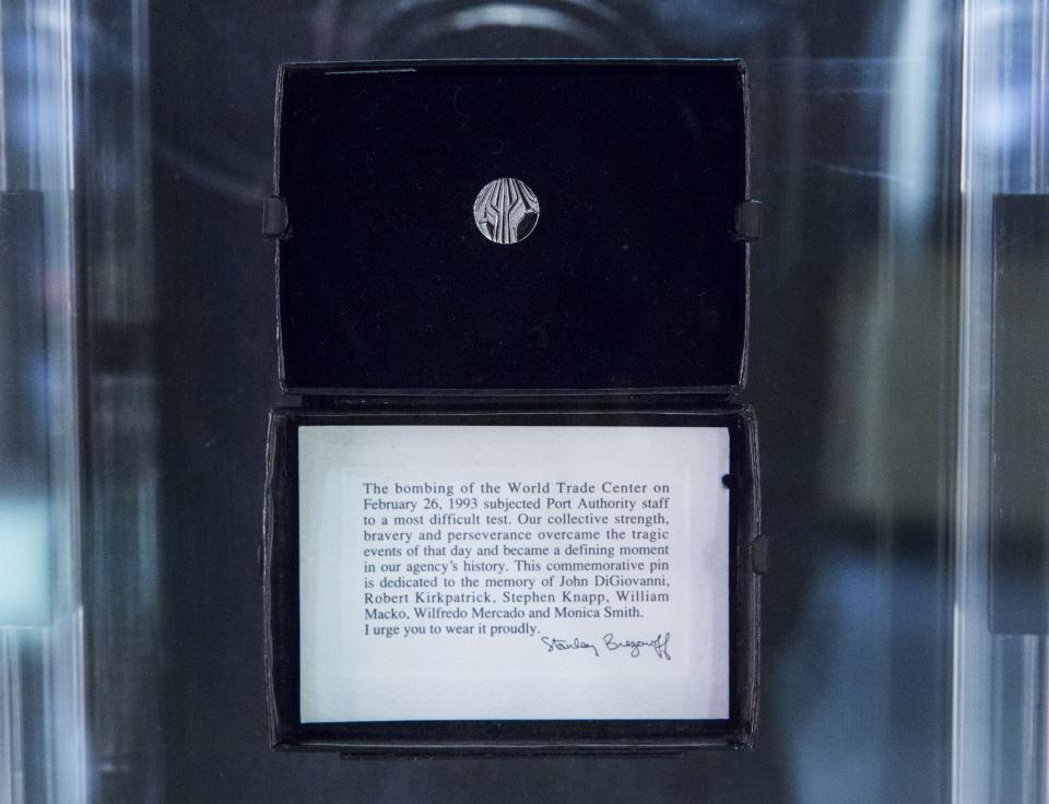 A small, silver-colored pin that Port Authority employees received after the 1993 bombing is displayed in a glass case.