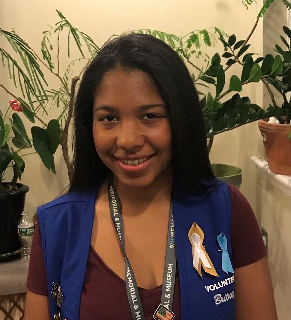 High school senior Britney Perez, a volunteer at the 9/11 Memorial & Museum, poses for a photo in her blue volunteer vest.