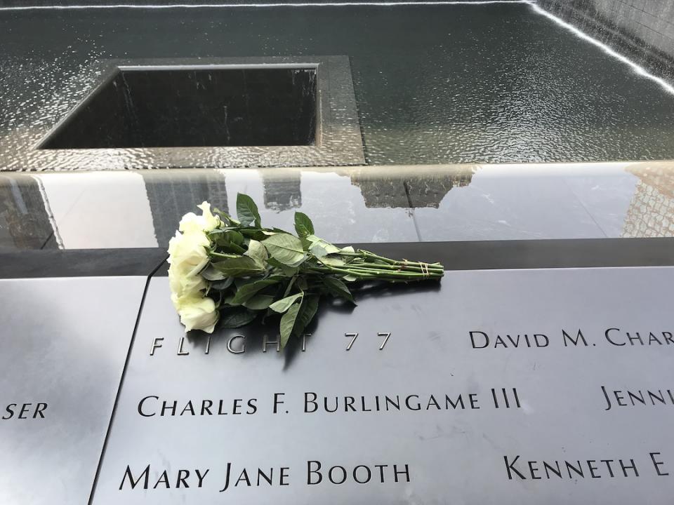 A bouquet of white roses sits at the section of the Memorial dedicated to the victims of Flight 77. The memorial pool can be seen in the background.