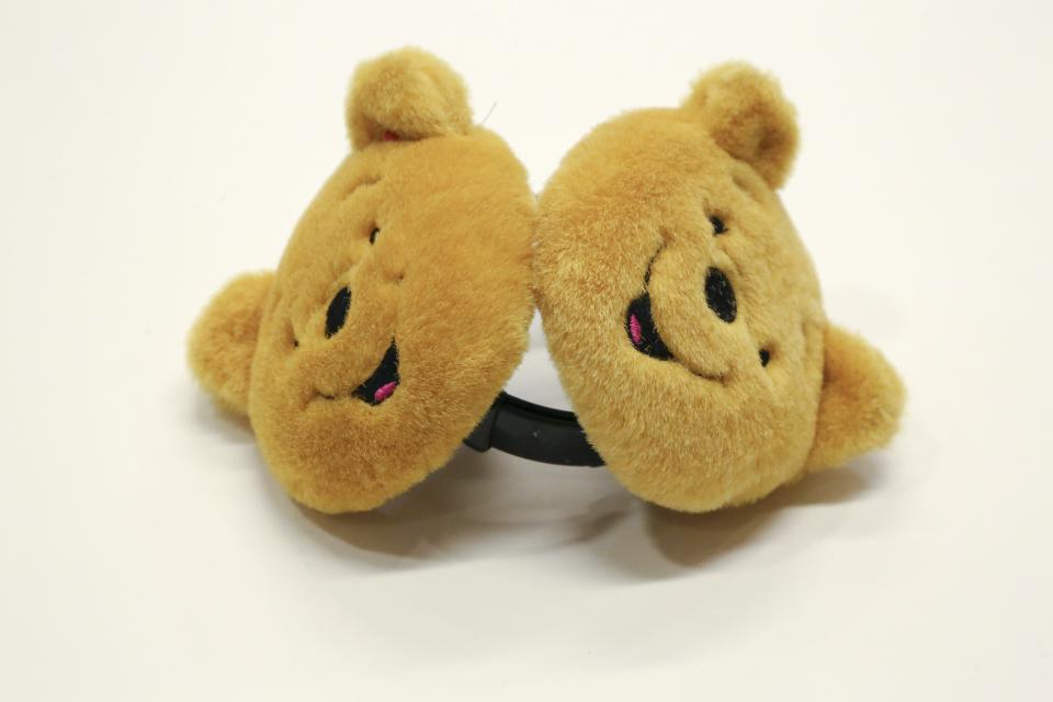 Winnie the Pooh earmuffs belonging to Asia S. Cottom are displayed on a white surface.