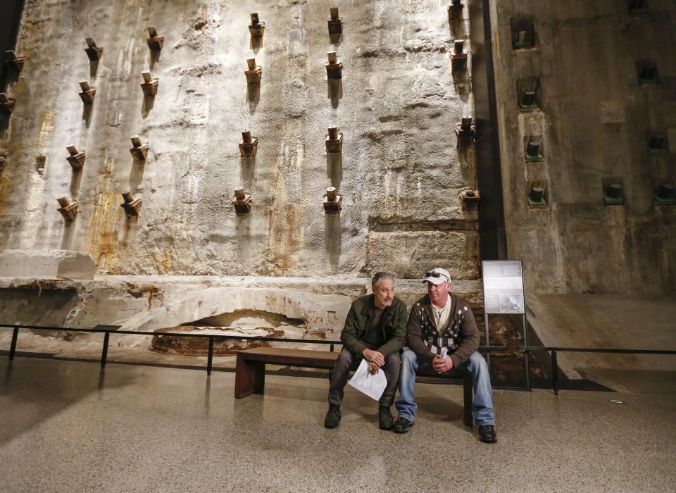 9/11 Memorial board member Jon Stewart and 9/11 responder and founder of the Fealgood Foundation John Feal sit on a bench next to the slurry wall in the Museum’s Foundation Hall.