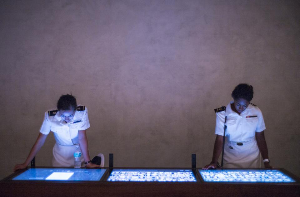 Two female members of the U.S. Navy look at information screens at the 9/11 Memorial Museum.