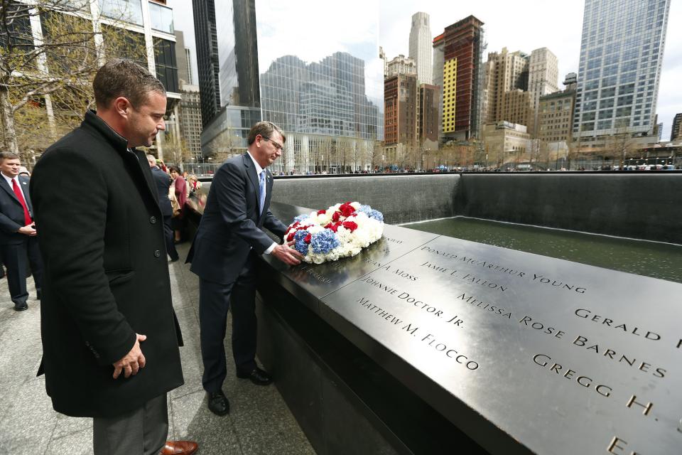 Defense Secretary Ash Carter places a red, white, and blue wreath on a bronze parapet at the 9/11 Memorial.
