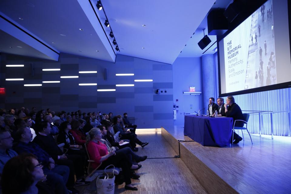Several people sit at a table onstage as they take part in a public program at the Museum Auditorium.