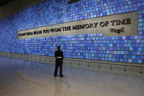 Retired Marine Corporal William Carpenter stands alone in a formal military uniform as he looks at artist Spencer Finch’s Memorial Hall installation “Trying to Remember the Color of the Sky on That September Morning.” The installation includes 2,983 watercolor squares, each in its own shade of blue, and the Virgil quote, “No day shall erase you from the memory of time.”