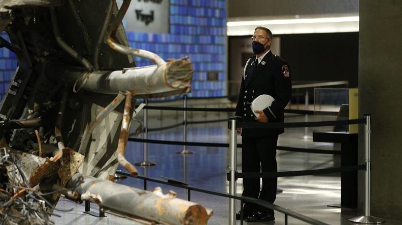 A man in an FDNY uniform looks at the section of television antennae that once sat atop the North Tower of the World Trade Center that is now in the 9/11 Memorial Museum. . 
