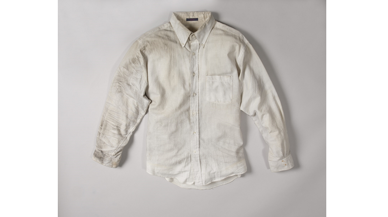 A smoke-stained white dress shirt worn by Walter Travers on February 26, 1993 is displayed on a white surface at the Museum.