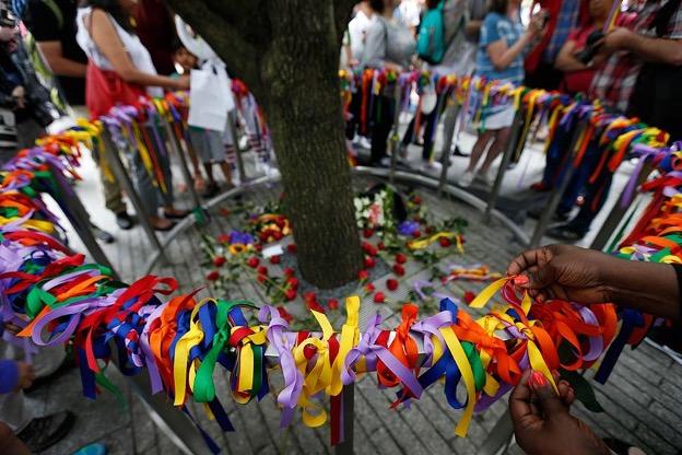 Visitors place and view colored ribbons around the the trunk of the Survivor Tree. 